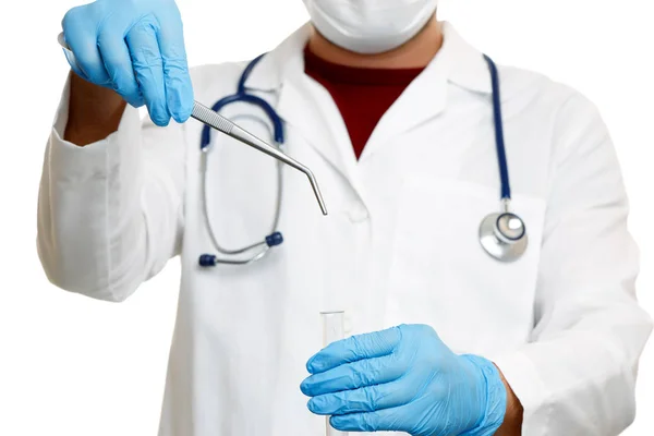 Imagem do médico com fonendoscópio em luvas de borracha azul segurando pinças — Fotografia de Stock