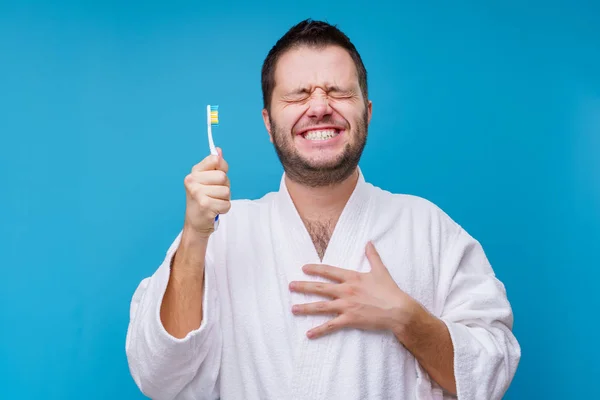 Foto van de mens met gesloten ogen met tandenborstel in handen en in witte vacht, geïsoleerd — Stockfoto
