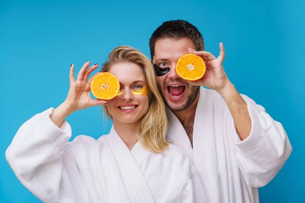 Foto de mujer feliz y hombre con naranjas cerca del ojo — Foto de Stock