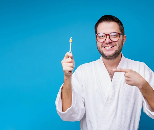 Foto av man med glasögon i vit kappa med tandborste i händerna — Stockfoto