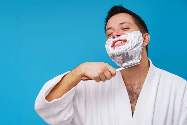 Obrázek šťastného člověka při holení v bílém plášti — Stock fotografie