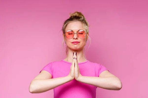 Фото блондинки в розовой футболке, медитирующей — стоковое фото