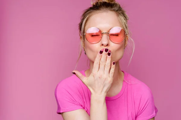 Изображение блондинки в розовой футболке, дующей в поцелуй — стоковое фото