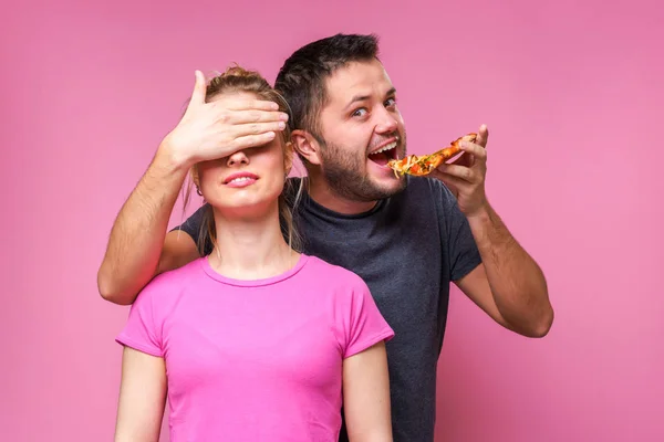 Beeld van de mens met pizza in handen van het sluiten van de ogen van de vrouw — Stockfoto