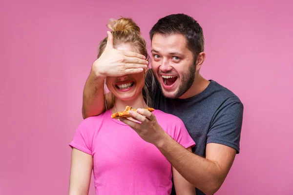 Foto van de man met pizza in handen van het sluiten van de ogen van de vrouw — Stockfoto