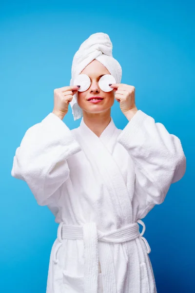 Foto van jonge vrouw in witte vacht en handdoek op haar hoofd met wattenschijfje in de hand — Stockfoto
