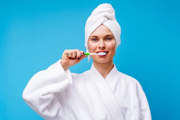 Foto di donna in cappotto bianco e asciugamano sulla testa lavarsi i denti — Foto Stock