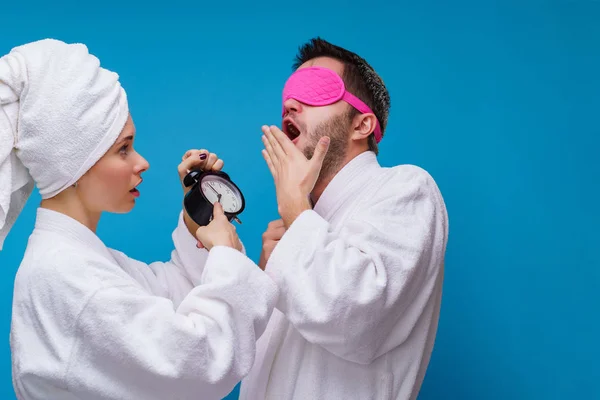 Изображение женщины с будильником и мужчиной с розовой повязкой на глазах — стоковое фото