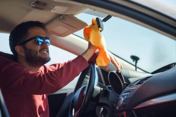 Foto de morena en gafas de sol espejo de lavado sentado en el coche —  Fotos de Stock