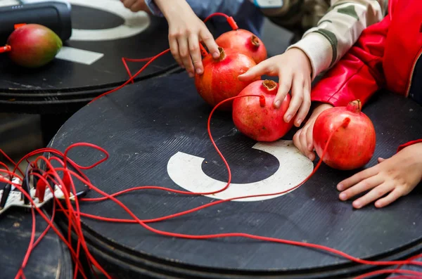 Obrázek granátové jablko a manga s červenými dráty na černém stole — Stock fotografie