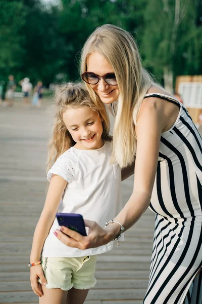 Kép boldog nő és lánya vesz selfie az utcán a nyári napon — Stock Fotó