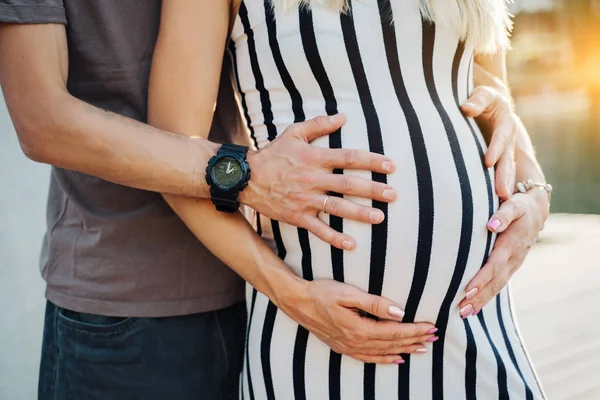 Foto van zwangere vrouw en man knuffelen haar op lopen — Stockfoto