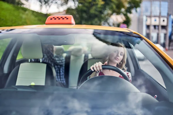 Photo through windshield of female driver on blurry background — Stock Photo, Image