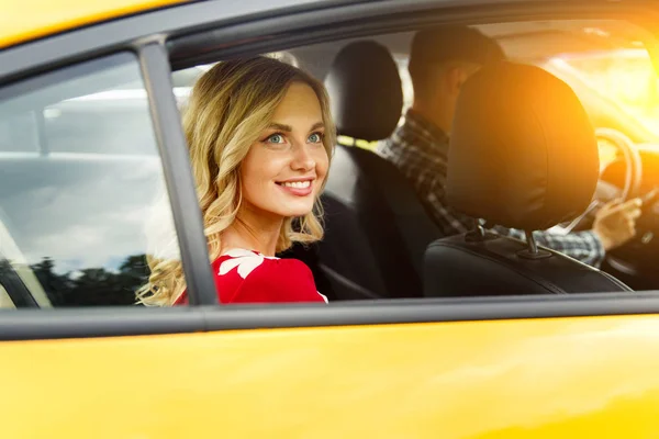 Foto de mujer feliz sentada en el asiento trasero de taxi amarillo en verano . —  Fotos de Stock