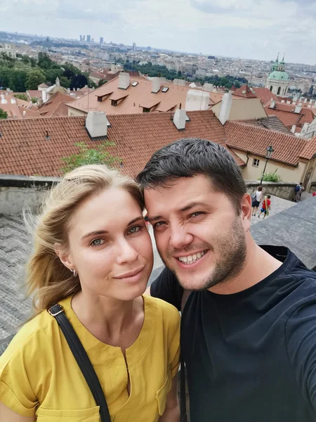 Image of smiling couple on walk in city against backdrop of attractions. — Stock Photo, Image