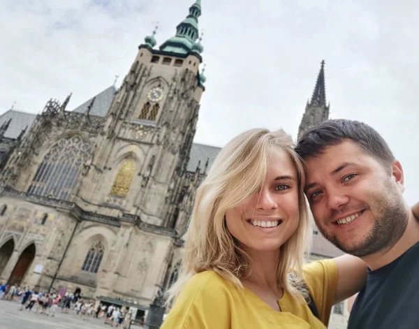 Picture of smiling couple on walk in city against backdrop of attractions. — Stock Photo, Image