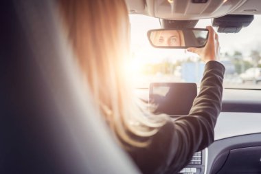 Arabanın direksiyonunda oturan sarışın arkasından fotoğraf.