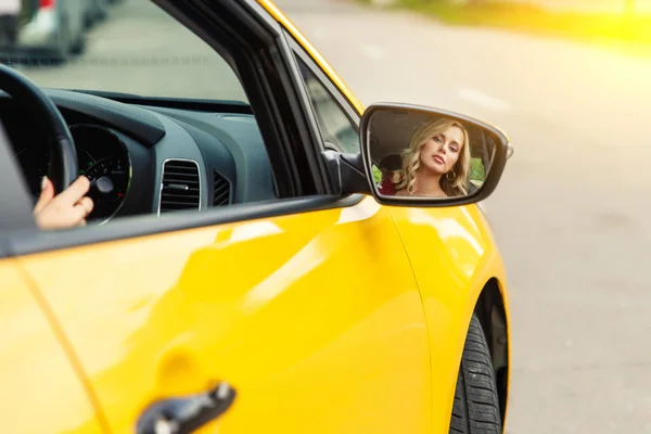Foto del conductor femenino reflejándose en el espejo amarillo del taxi . — Foto de Stock