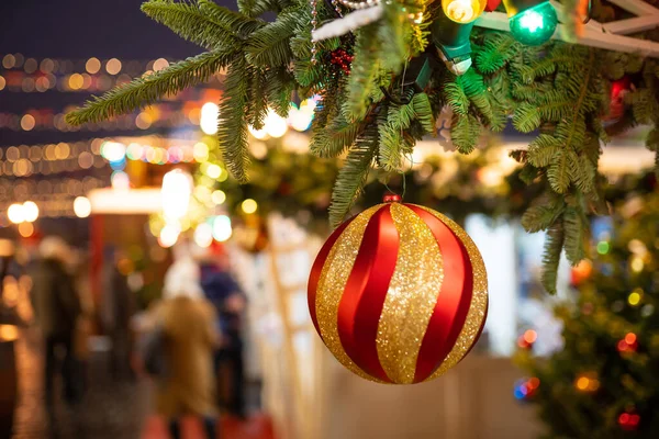 Foto von rot mit goldener Weihnachtskugel am Weihnachtsbaum auf verschwommenem Hintergrund am Abend. — Stockfoto