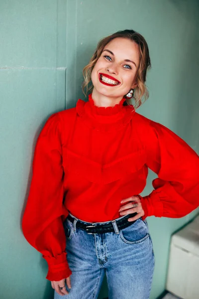 Rubia alegre en suéter rojo sobre fondo verde — Foto de Stock