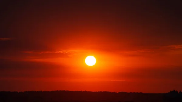 Belo sol vermelho sobre a cidade ao pôr do sol . — Fotografia de Stock