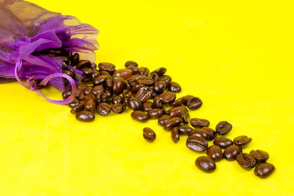 Roasted Coffee Beans Spilled Purple Pouch Yellow Background — Stock Photo, Image