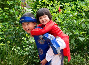 Gülümse, sevimli. Gülümseyen sevimli çocuk kız kardeşi Hai Duong 'u taşıyor.