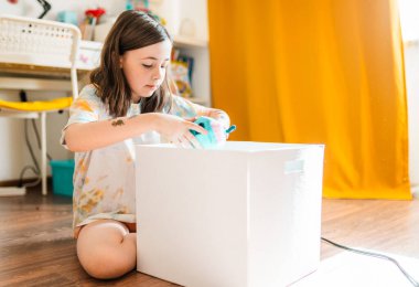 Child cleans up her toys. Little girl tydies up her room..