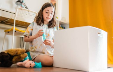 Child cleans up her toys. Little girl tydies up her room..