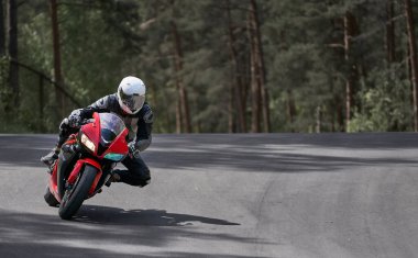 Motosikletler asfalt üzerinde sıranın üzerinde dikiliyor.