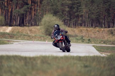 25-05-2020 Riga, Letonya. Motosikletli yolda, yandan, yakın mesafeden gidiyor..