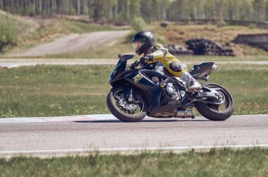 25-05-2020 Riga, Letonya. Motosikletli yolda, yandan, yakın mesafeden gidiyor..