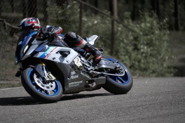 25-05-2020 Riga, Letonya. Motosikletli yolda, yandan, yakın mesafeden gidiyor..