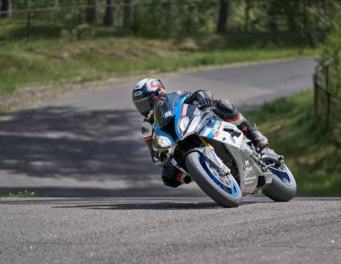 25-05-2020 Riga, Letonya. Motosikletli yolda, yandan, yakın mesafeden gidiyor..