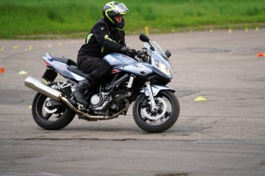 25-05-2020 Riga, Letonya. Motosikletli yola çıkıyor. Bir motosikletçi motosikleti kontrol etmeyi öğrenir.