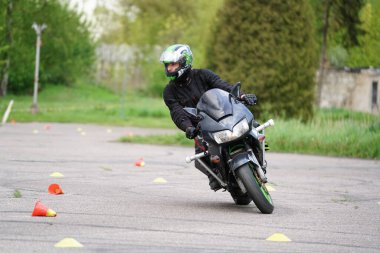 25-05-2020 Riga, Letonya. Motosikletli yola çıkıyor. Bir motosikletçi motosikleti kontrol etmeyi öğrenir.