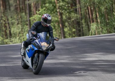 Motosikletli yola çıkıyor. Bir motosikletçi motosikleti kontrol etmeyi öğrenir.