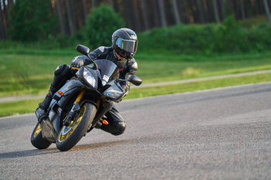 11-05-2020 Riga, Letonya. Motosikletli bir adam yolda. Motosiklet turunda boş bir yolda araba sürerken eğleniyorum. bireysel metniniz için kopyalama alanı.