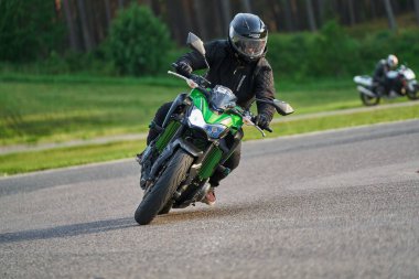 11-05-2020 Riga, Letonya. Motosikletli bir adam yolda. Motosiklet turunda boş bir yolda araba sürerken eğleniyorum. bireysel metniniz için kopyalama alanı.