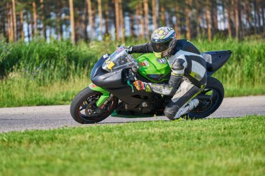 11-05-2020 Riga, Letonya. Motosikletli bir adam yolda. Motosiklet turunda boş bir yolda araba kullanırken eğleniyorum.