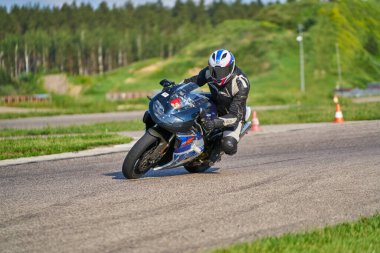 11-05-2020 Riga, Letonya. Motosikletli bir adam yolda. Motosiklet turunda boş bir yolda araba kullanırken eğleniyorum.