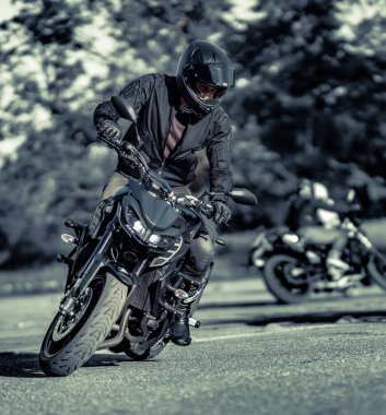 11-05-2020 Riga, Letonya. Motosikletli bir adam yolda. Motosiklet turunda boş bir yolda araba kullanırken eğleniyorum.