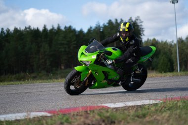 10-05-2020 Ropazi, Letonya motorsikletçisi boş asfalt yolda bisiklet sürüyor. spor bisikleti.