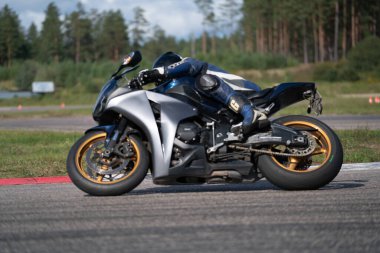 10-05-2020 Ropazi, Letonya motorsikletçisi boş asfalt yolda bisiklet sürüyor. spor bisikleti.