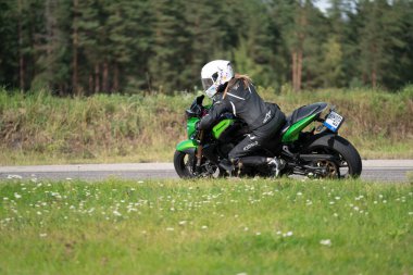 05-09-2020 Riga, Letonya Bisikletli Adam. Motosiklet turunda boş bir yolda araba sürerken eğleniyorum. bireysel metniniz için kopyalama alanı