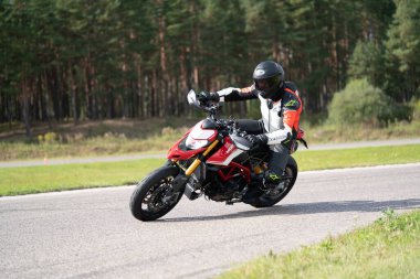 05-09-2020 Riga, Letonya Bisikletli Adam. Motosiklet turunda boş bir yolda araba sürerken eğleniyorum. bireysel metniniz için kopyalama alanı