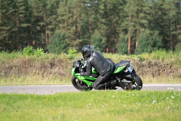 2020ラトビアのリガ道路に乗ってバイクに乗って男 オートバイツアーで空の道を走るのが楽しい 個々のテキストのコピースペースは — ストック写真