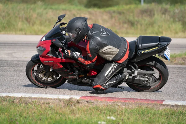 2020ラトビアのリガ道路に乗ってバイクに乗って男 オートバイツアーで空の道を走るのが楽しい 個々のテキストのコピースペースは — ストック写真