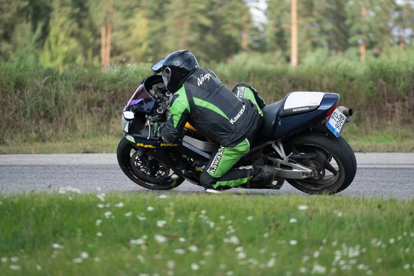 2020ラトビアのリガ道路に乗ってバイクに乗って男 オートバイツアーで空の道を走るのが楽しい 個々のテキストのコピースペースは — ストック写真