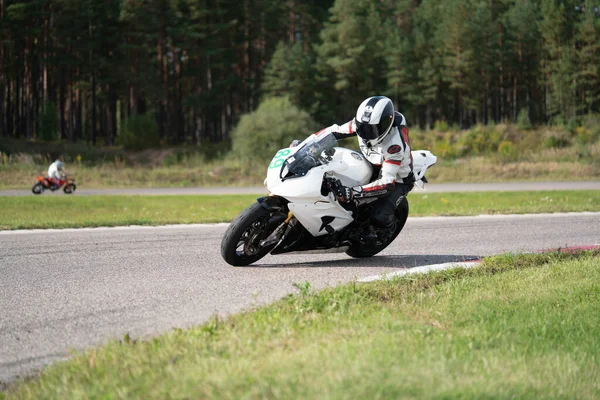 2020ラトビアのリガ道路に乗ってバイクに乗って男 オートバイツアーで空の道を走るのが楽しい 個々のテキストのコピースペースは — ストック写真